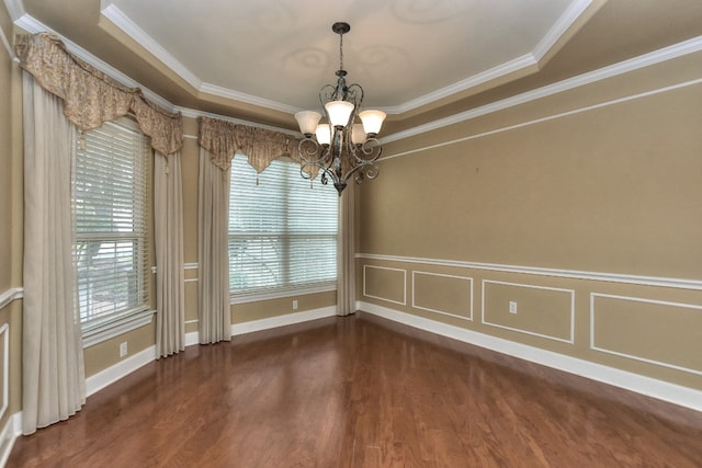 unfurnished dining area featuring dark hardwood / wood-style flooring, a raised ceiling, an inviting chandelier, and crown molding