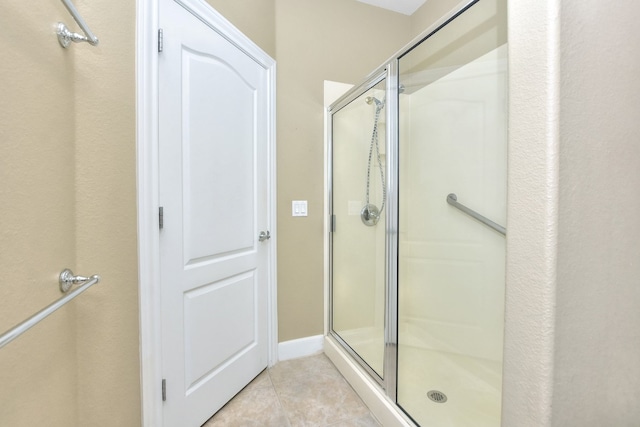 bathroom with tile patterned flooring and a shower with shower door