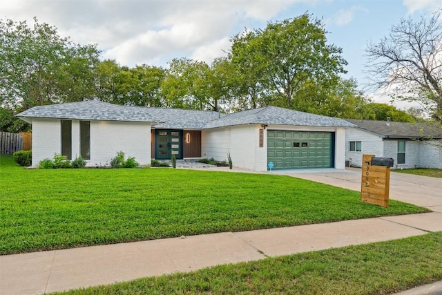 view of front of property with a front yard and a garage