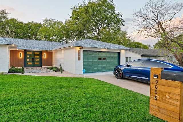 view of front facade featuring a lawn and a garage