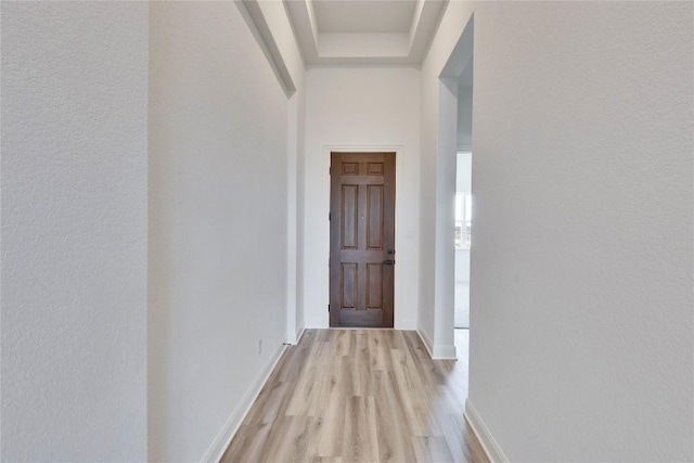 hallway with light wood-type flooring and baseboards