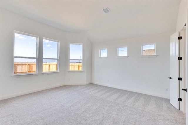 spare room featuring visible vents, light colored carpet, and baseboards