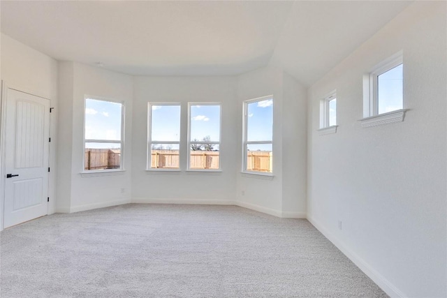 spare room featuring baseboards and light colored carpet