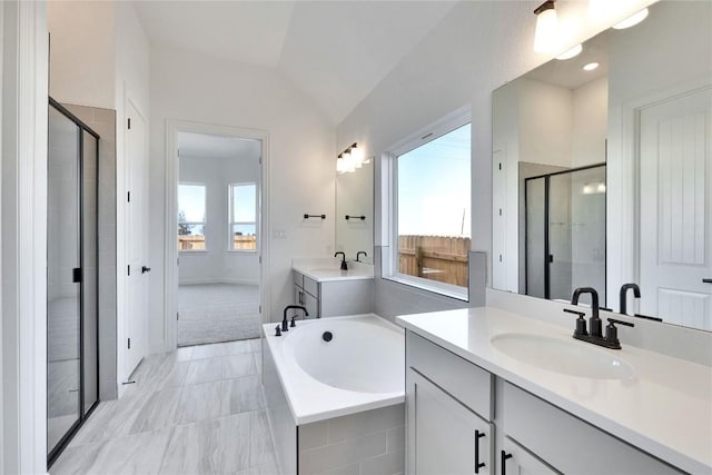full bathroom with lofted ceiling, two vanities, a stall shower, a sink, and a garden tub