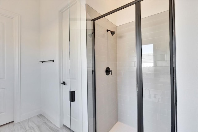 bathroom featuring a shower stall and marble finish floor