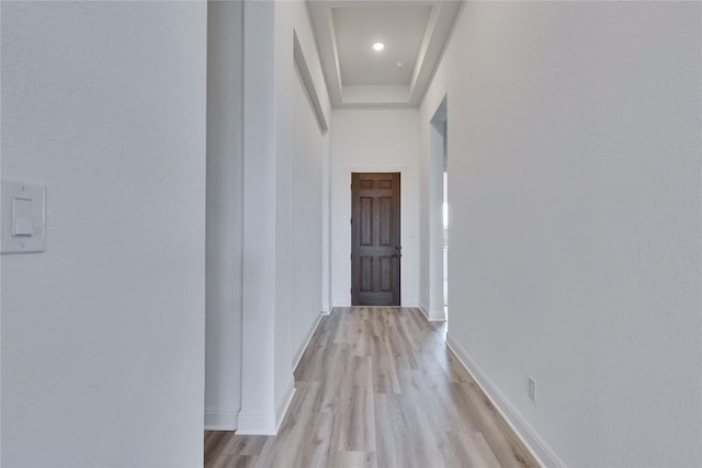 corridor featuring baseboards and light wood-type flooring