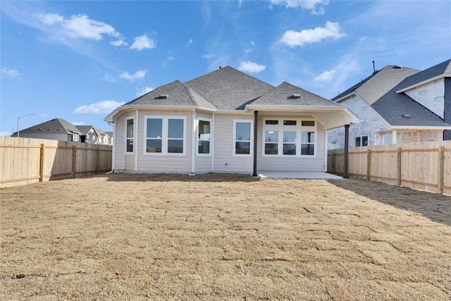 back of property featuring roof with shingles and a fenced backyard