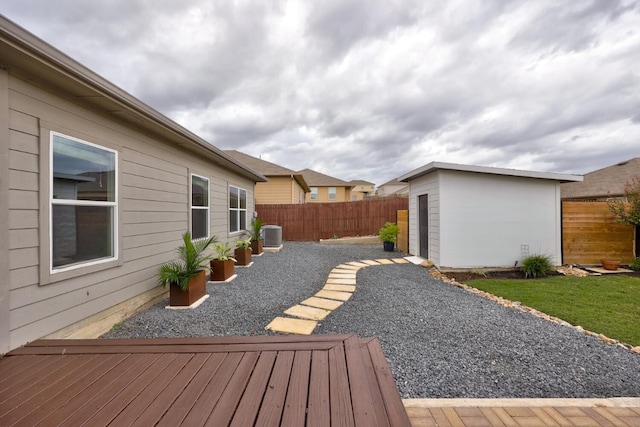 wooden terrace featuring a patio and a shed