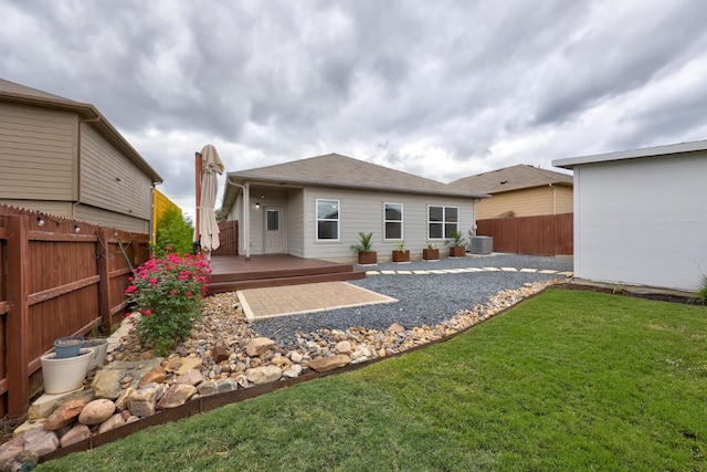 back of property with central air condition unit, a deck, a yard, and a patio area