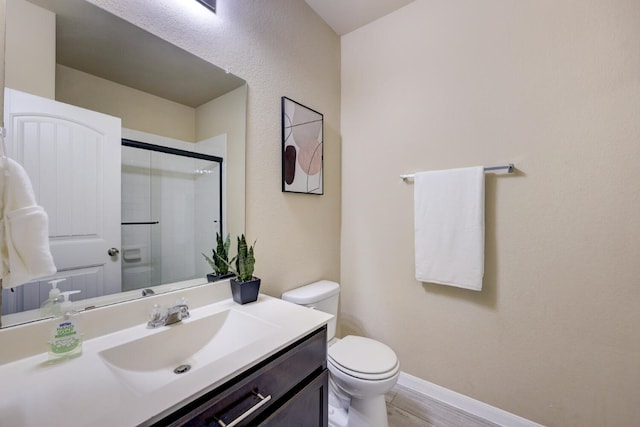 bathroom with walk in shower, vanity, hardwood / wood-style flooring, and toilet