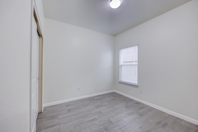 unfurnished bedroom with light wood-type flooring and a closet