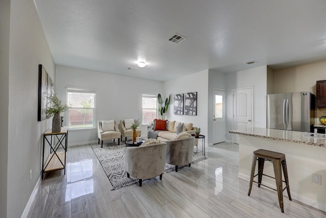 living room with a textured ceiling and light hardwood / wood-style floors