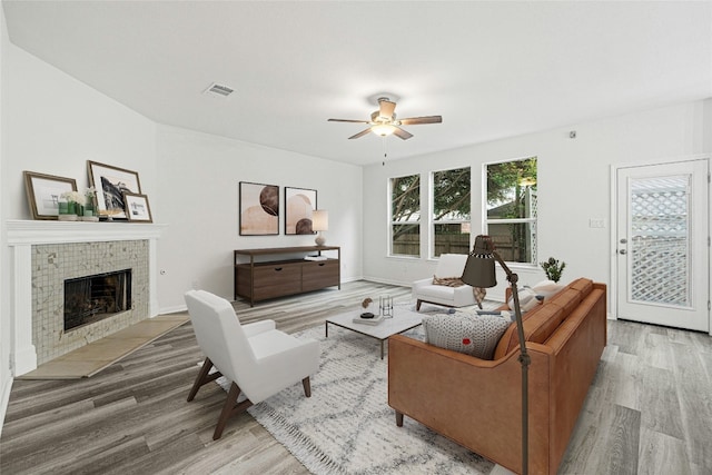 living room featuring a fireplace, hardwood / wood-style flooring, and ceiling fan