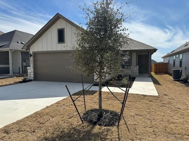192 Spirit St, Elgin, TX 78621 - view of front of house with board and batten siding, central air condition unit, concrete driveway, and an attached garage