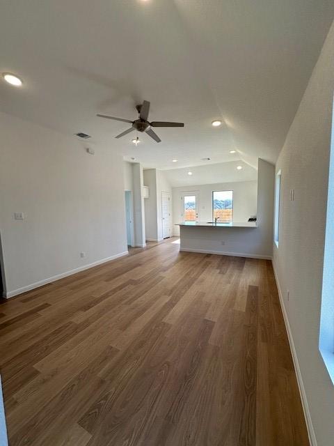 192 Spirit St, Elgin, TX 78621 - unfurnished living room featuring wood finished floors, a ceiling fan, recessed lighting, and vaulted ceiling