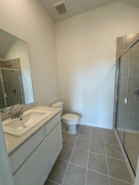 192 Spirit St, Elgin, TX 78621 - full bathroom featuring vanity, tile patterned flooring, a stall shower, and vaulted ceiling