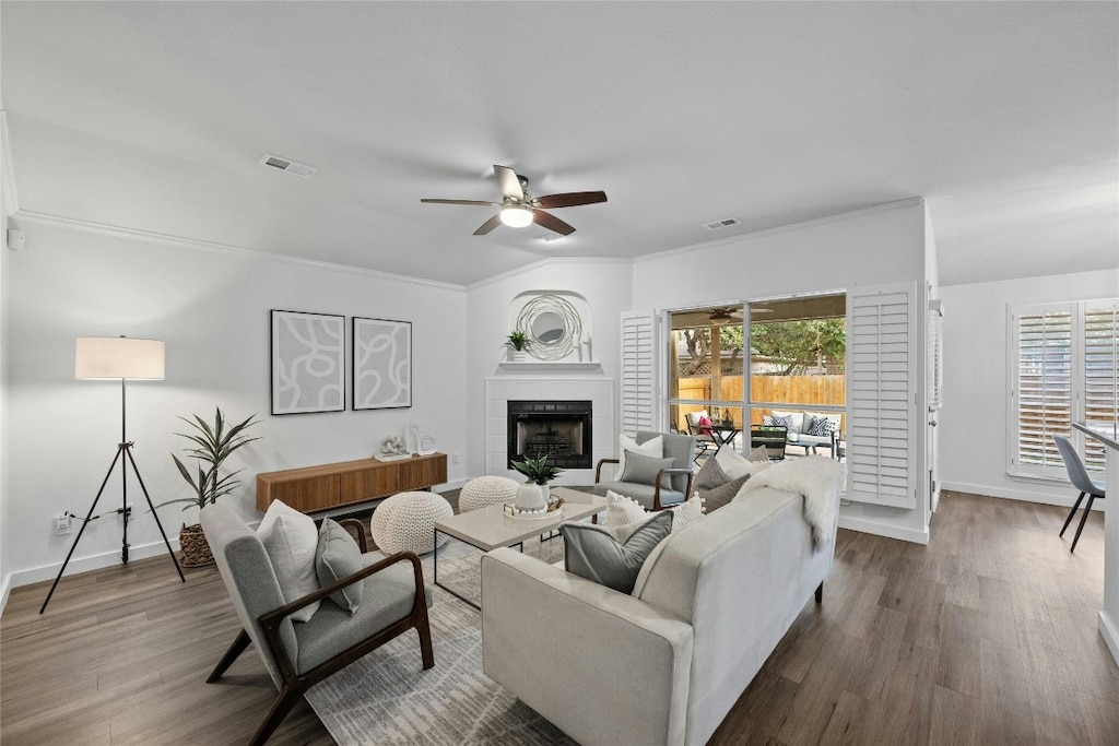 living room featuring crown molding, ceiling fan, and wood-type flooring