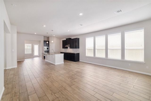 unfurnished living room featuring light hardwood / wood-style floors and sink