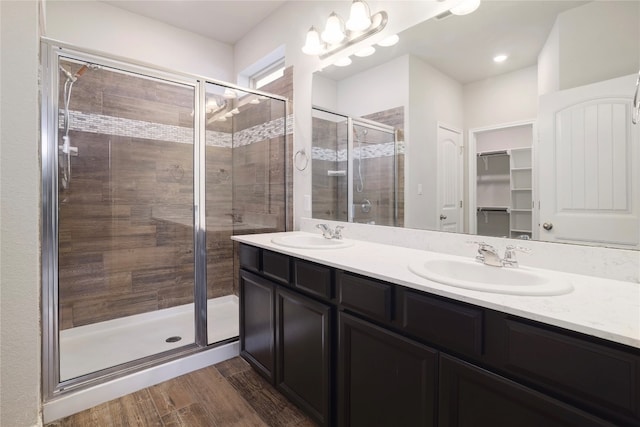 bathroom with vanity, wood-type flooring, and a shower with door