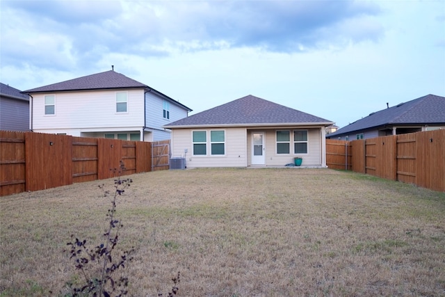 back of house with a lawn and central AC