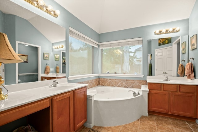 bathroom with vanity, tile patterned floors, a tub, and vaulted ceiling