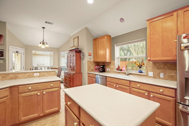 kitchen with stainless steel appliances, vaulted ceiling, a notable chandelier, and plenty of natural light