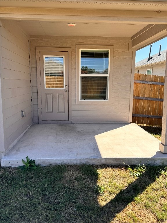 view of exterior entry with a patio area