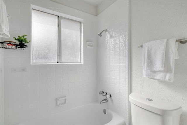 bathroom with tiled shower / bath and toilet