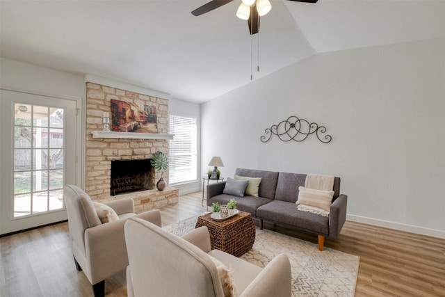 living room with a wealth of natural light, ceiling fan, lofted ceiling, and light wood-type flooring