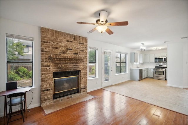 910 Crieff Cross Dr, Pflugerville, TX 78660 - unfurnished living room featuring a brick fireplace, ceiling fan, and baseboards