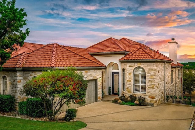 mediterranean / spanish-style home with a garage