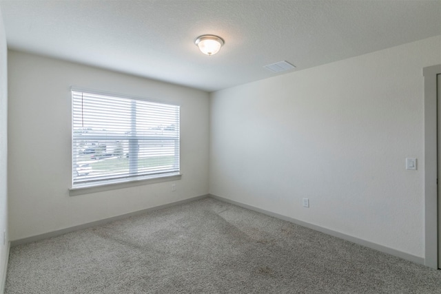 empty room with carpet and a textured ceiling