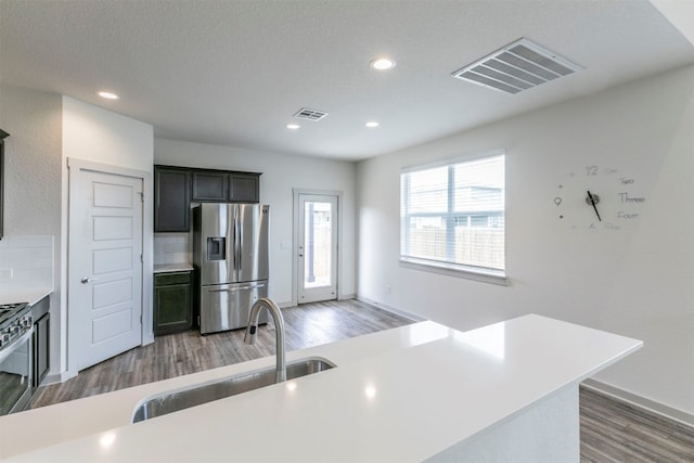 kitchen with stainless steel appliances, tasteful backsplash, dark wood-type flooring, and sink