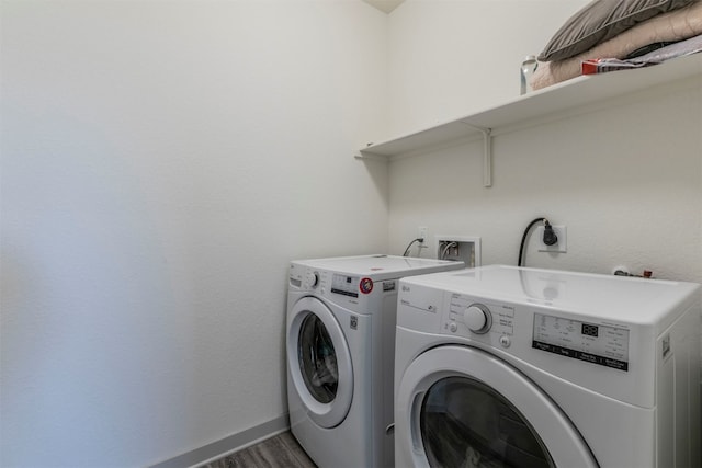 clothes washing area featuring washing machine and dryer and dark hardwood / wood-style floors