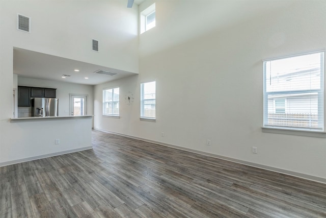 unfurnished living room with dark hardwood / wood-style floors and a high ceiling