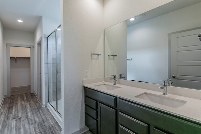 bathroom featuring hardwood / wood-style flooring, vanity, and a shower with shower door