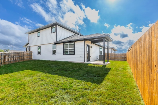 rear view of house with a yard and a patio