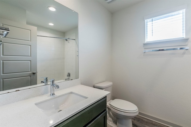 bathroom featuring hardwood / wood-style floors, vanity, a tile shower, and toilet