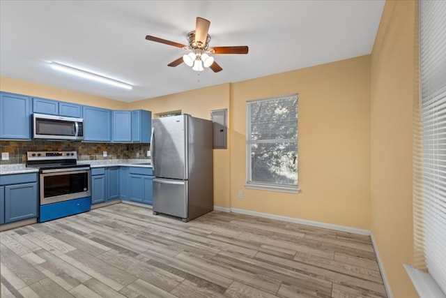 kitchen with tasteful backsplash, light hardwood / wood-style flooring, appliances with stainless steel finishes, and blue cabinets