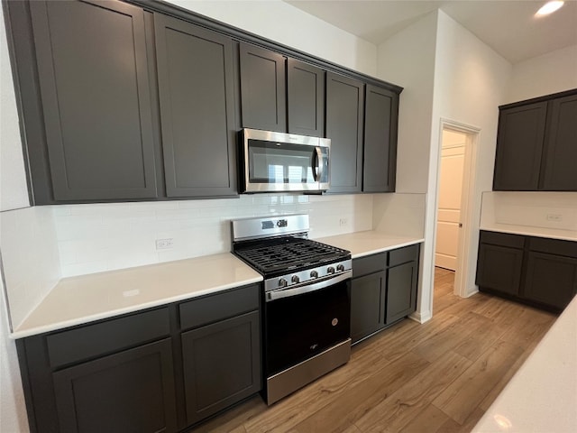 kitchen with decorative backsplash, stainless steel appliances, and light hardwood / wood-style floors