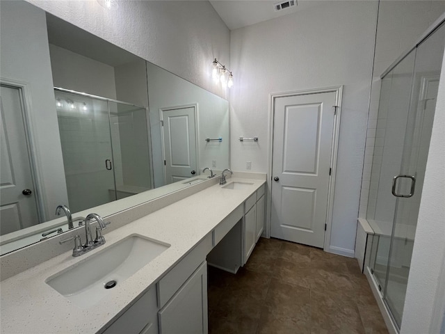 bathroom featuring a shower with door and vanity