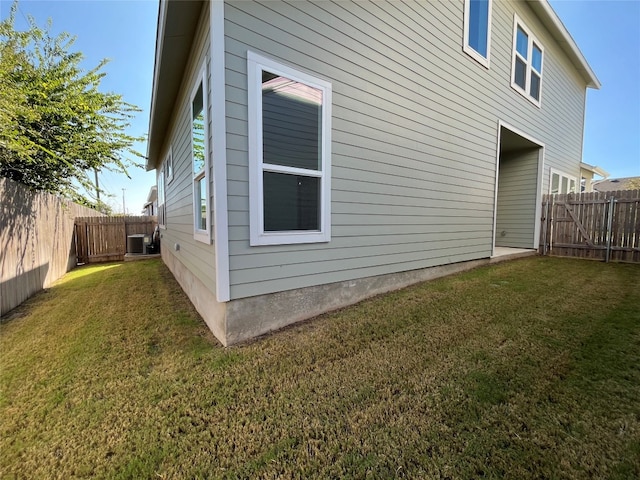 view of home's exterior featuring central AC unit and a yard