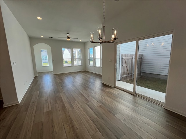 unfurnished living room with wood-type flooring and ceiling fan with notable chandelier