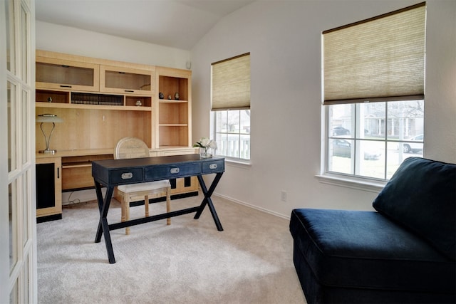 carpeted home office with vaulted ceiling