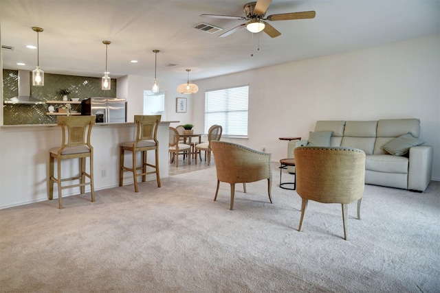 carpeted living room featuring ceiling fan