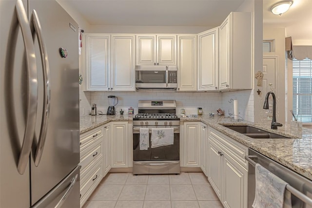 2000 Cullen Ave Unit 9, Austin, TX 78757 - kitchen featuring stainless steel appliances, backsplash, light tile patterned flooring, white cabinets, and light stone countertops