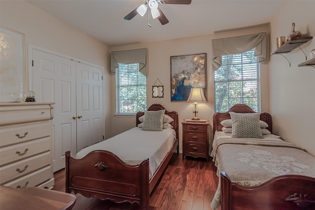 bedroom with dark wood-type flooring, ceiling fan, multiple windows, and a closet