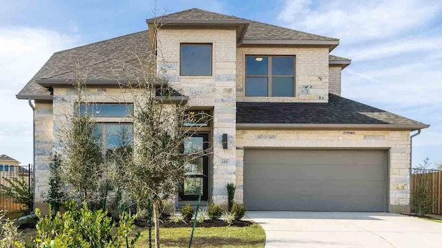 view of front of property with stone siding, fence, and driveway