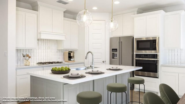 kitchen featuring visible vents, appliances with stainless steel finishes, light countertops, and a sink