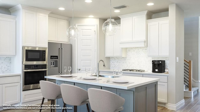 121 La Venta Loop, Liberty Hill, TX 78642 - kitchen featuring stainless steel appliances, light countertops, backsplash, white cabinetry, and recessed lighting